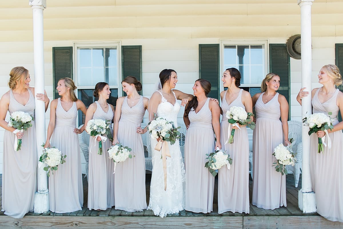 Arielle Peters Photography | Bride and bridesmaids laughing on historic front porch on wedding day at St. Joe Farm in Granger, Indiana.