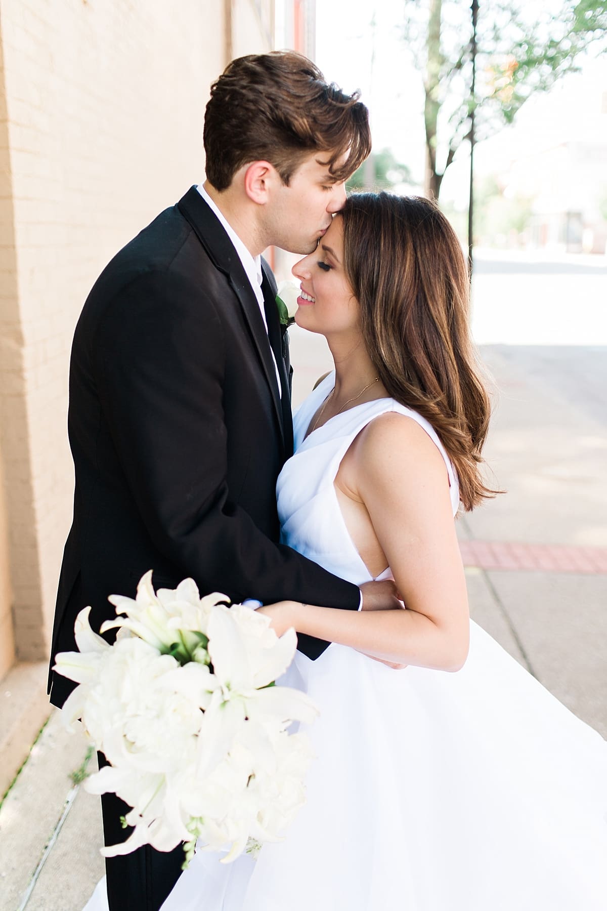 Arielle Peters Photography | Bride and groom kissing in city streets on wedding day at Loft 310 in Kalamazoo, Michigan.