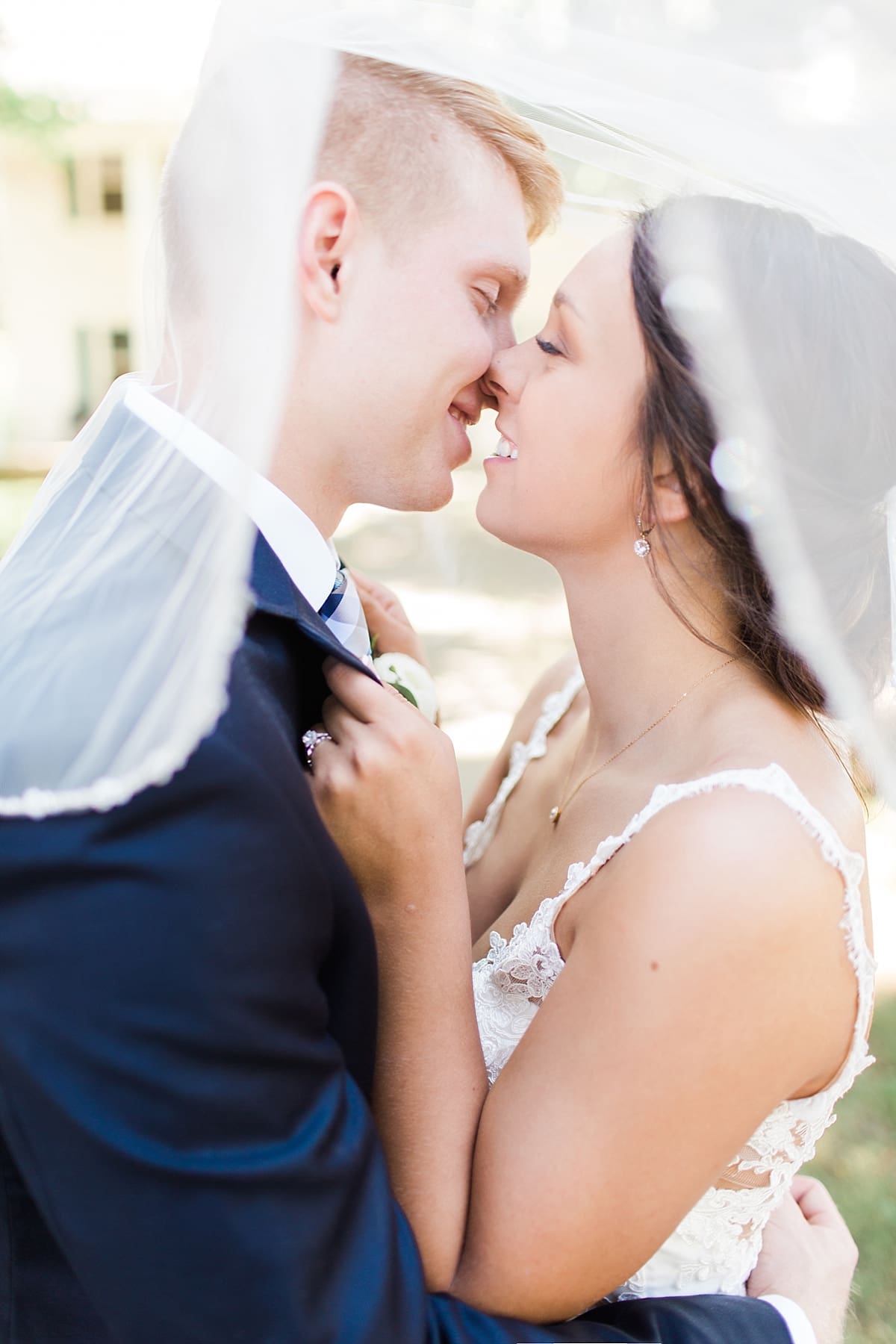 Arielle Peters Photography | Bride and groom kissing under veil on historic farm on wedding day at St. Joe Farm in Granger, Indiana.