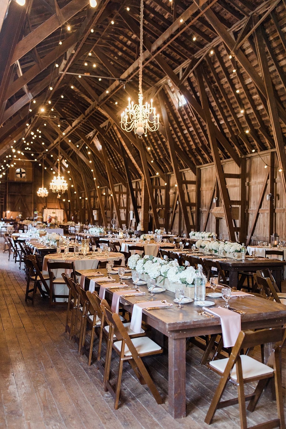 Arielle Peters Photography | Wedding reception table settings and floral arrangements inside historic barn on wedding day at St. Joe Farm in Granger, Indiana.