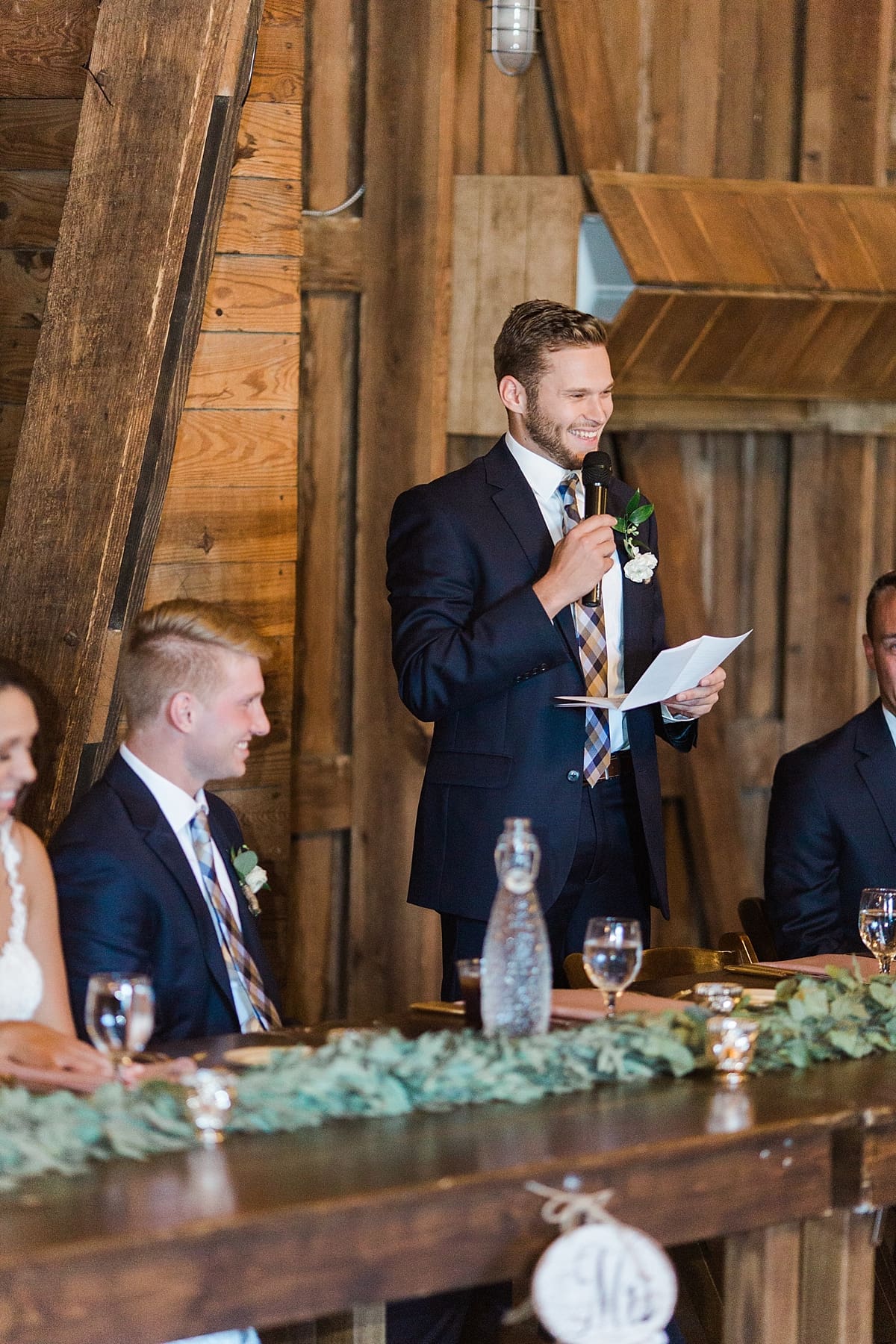 Arielle Peters Photography | Best man giving a speech at wedding reception inside historic barn on wedding day at St. Joe Farm in Granger, Indiana.
