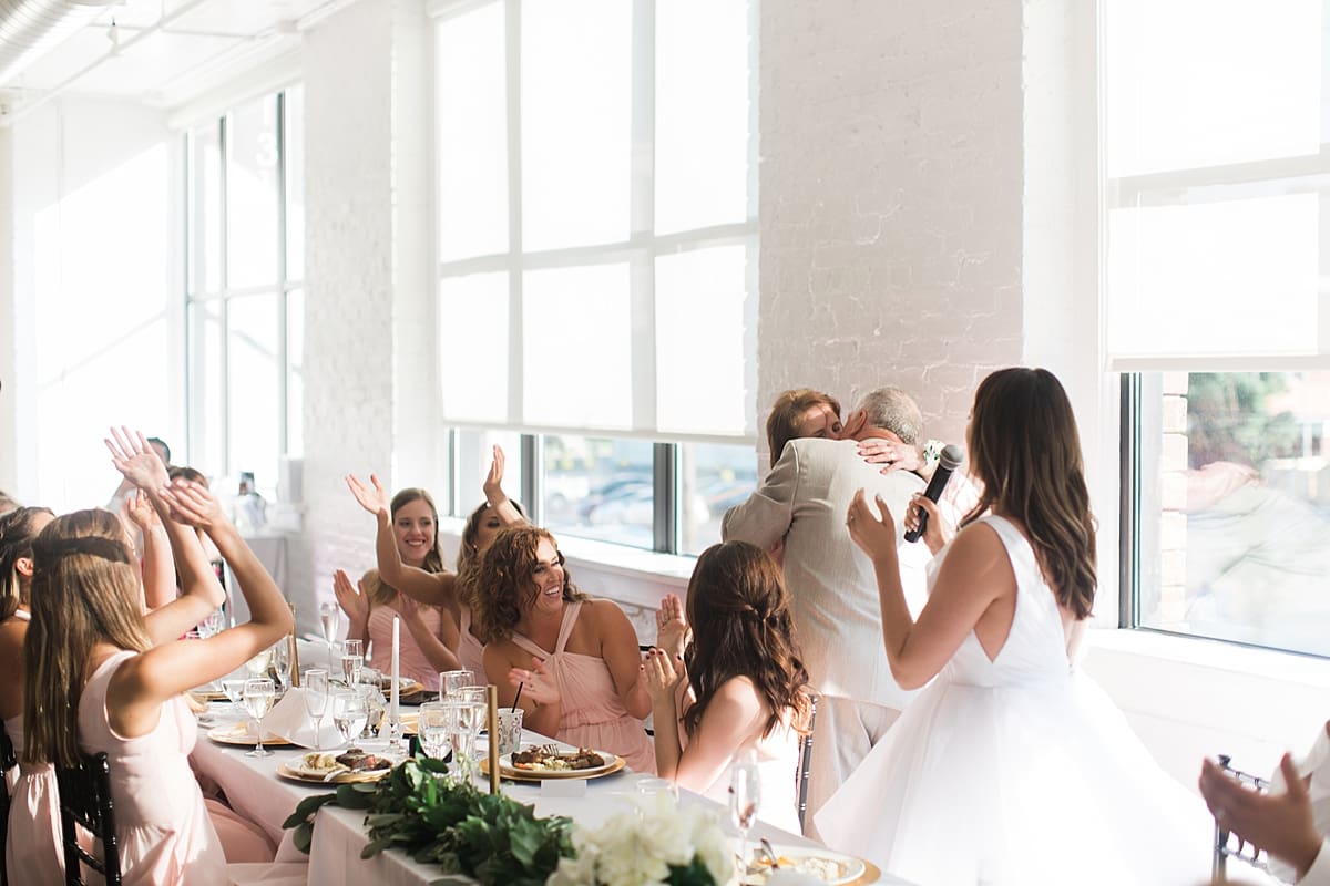 Arielle Peters Photography | Wedding guests cheering at wedding reception on wedding day at Loft 310 in Kalamazoo, Michigan.