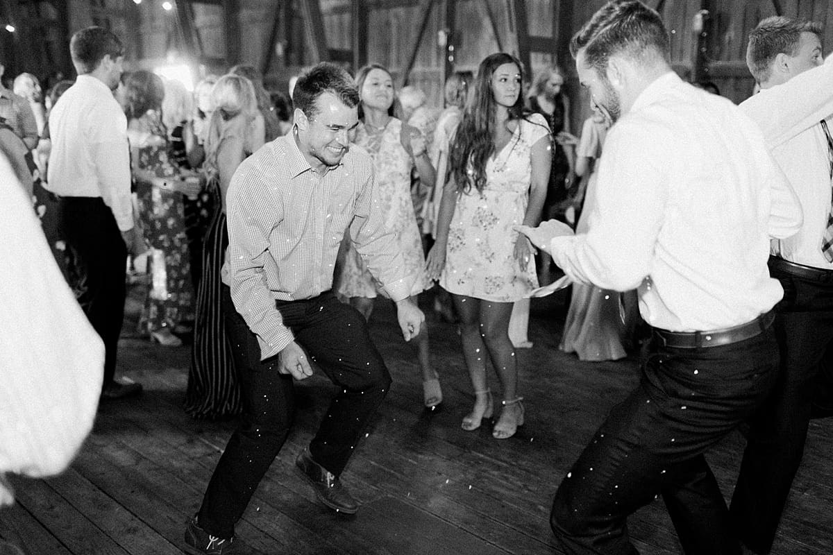 Arielle Peters Photography | Wedding guests dancing inside historic barn on wedding day at St. Joe Farm in Granger, Indiana.