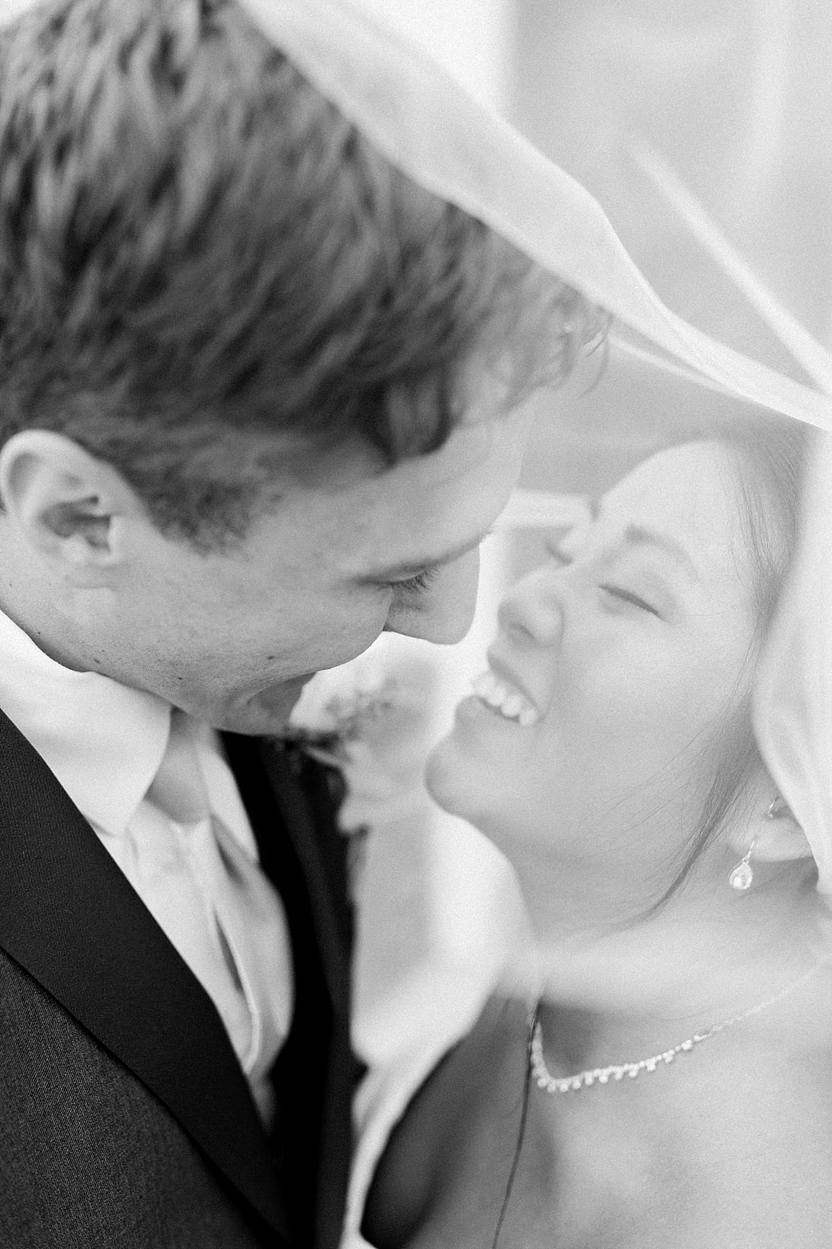 Arielle Peters Photography | Bride and groom smiling under veil outside on wedding day in Fort Wayne, Indiana. 