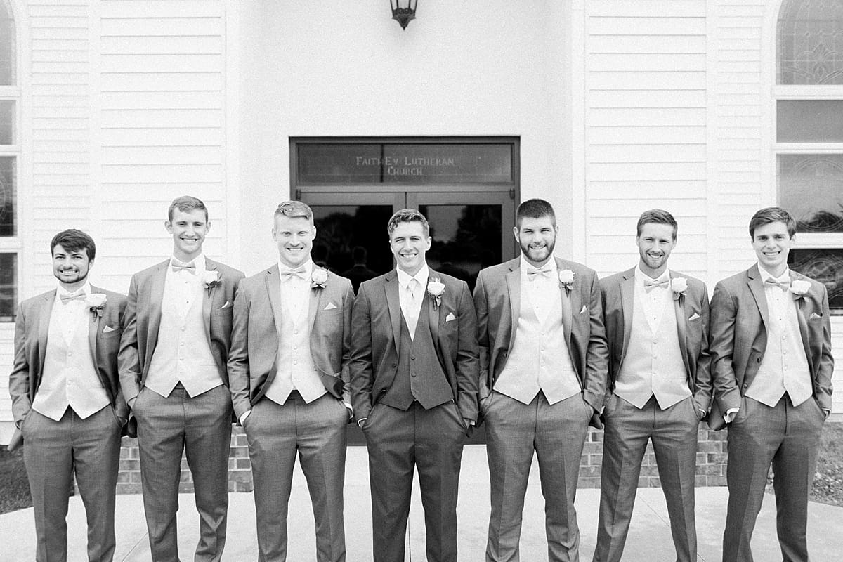 Arielle Peters Photography | Groom and groomsmen smiling outside church on wedding day in Fort Wayne, Indiana. 