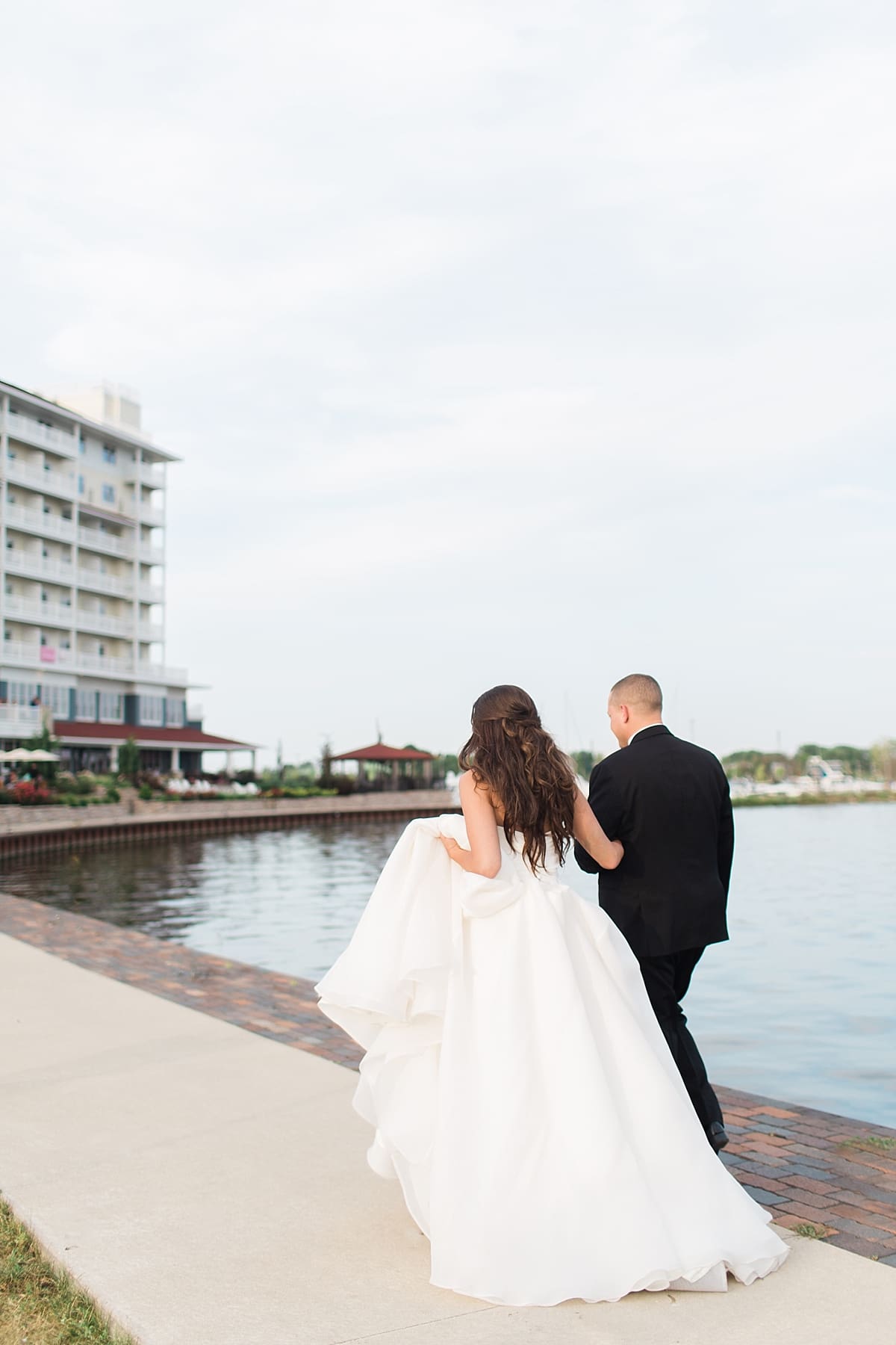 Arielle Peters Photography | Bride and groom walking by the water at The Inn at Harbor Springs in St. Joseph, Michigan.