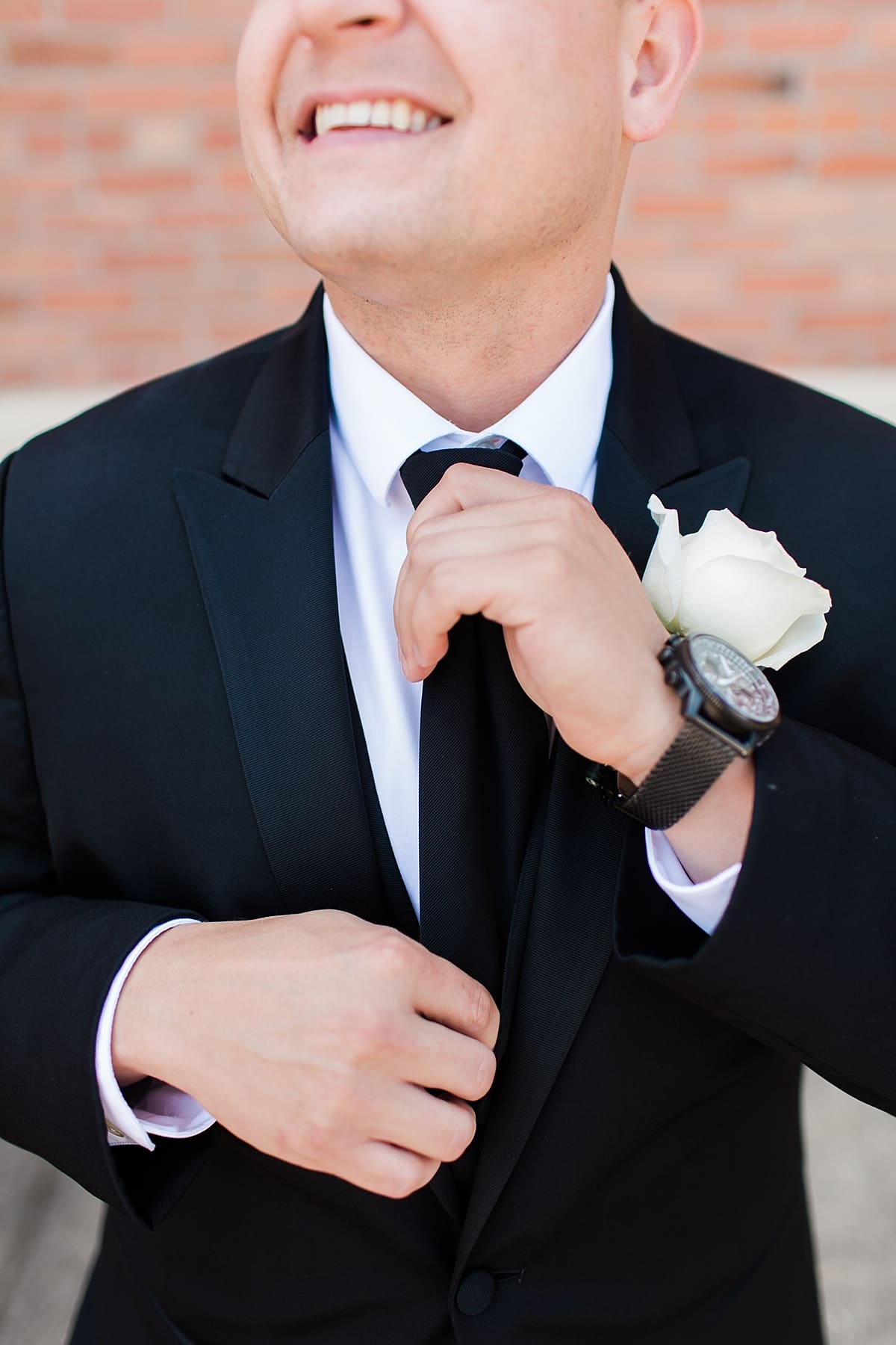 Arielle Peters Photography | Groom putting on his tie outside on summer wedding day at The Inn at Harbor Springs in St. Joseph, Michigan.