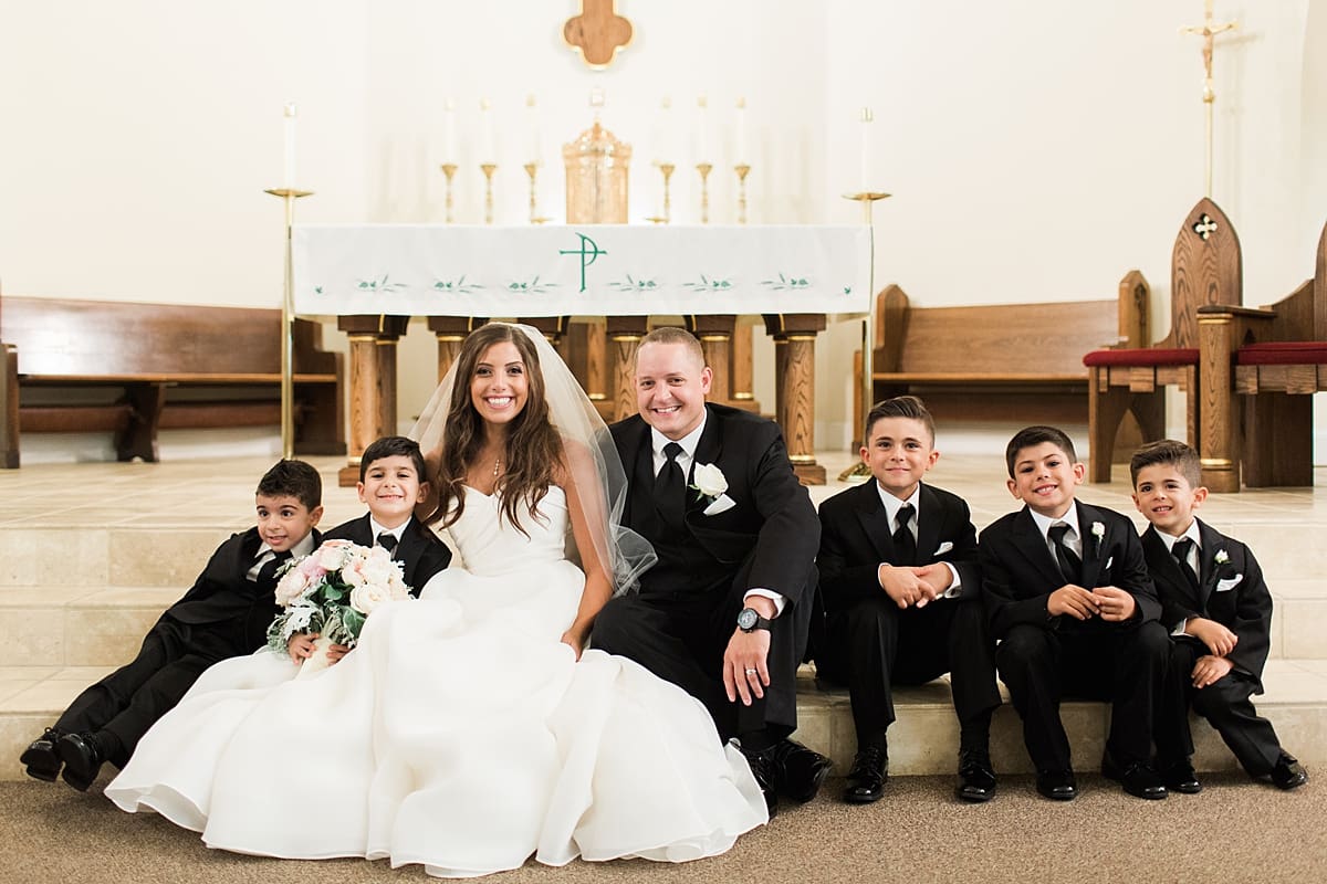 Arielle Peters Photography | Bride and groom smiling with kids inside church on summer wedding day at The Inn at Harbor Springs in St. Joseph, Michigan.