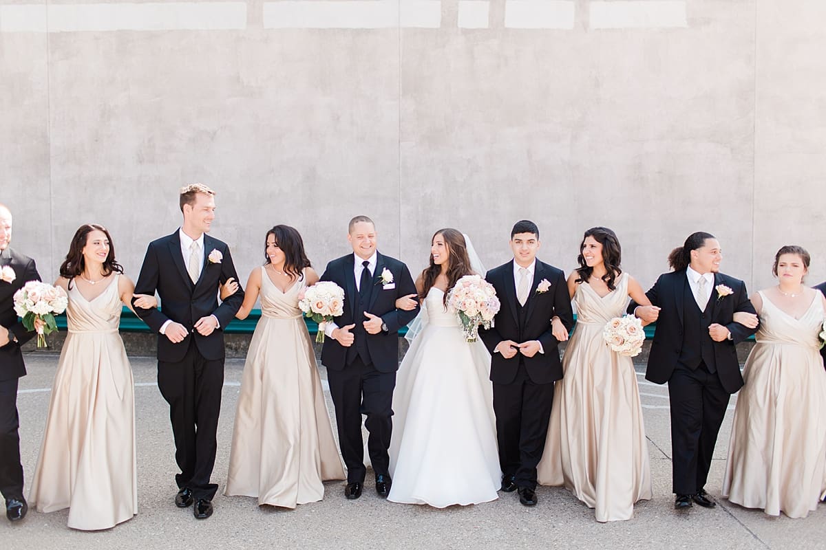 Arielle Peters Photography | Wedding party linking arms outside on summer wedding day at The Inn at Harbor Springs in St. Joseph, Michigan.