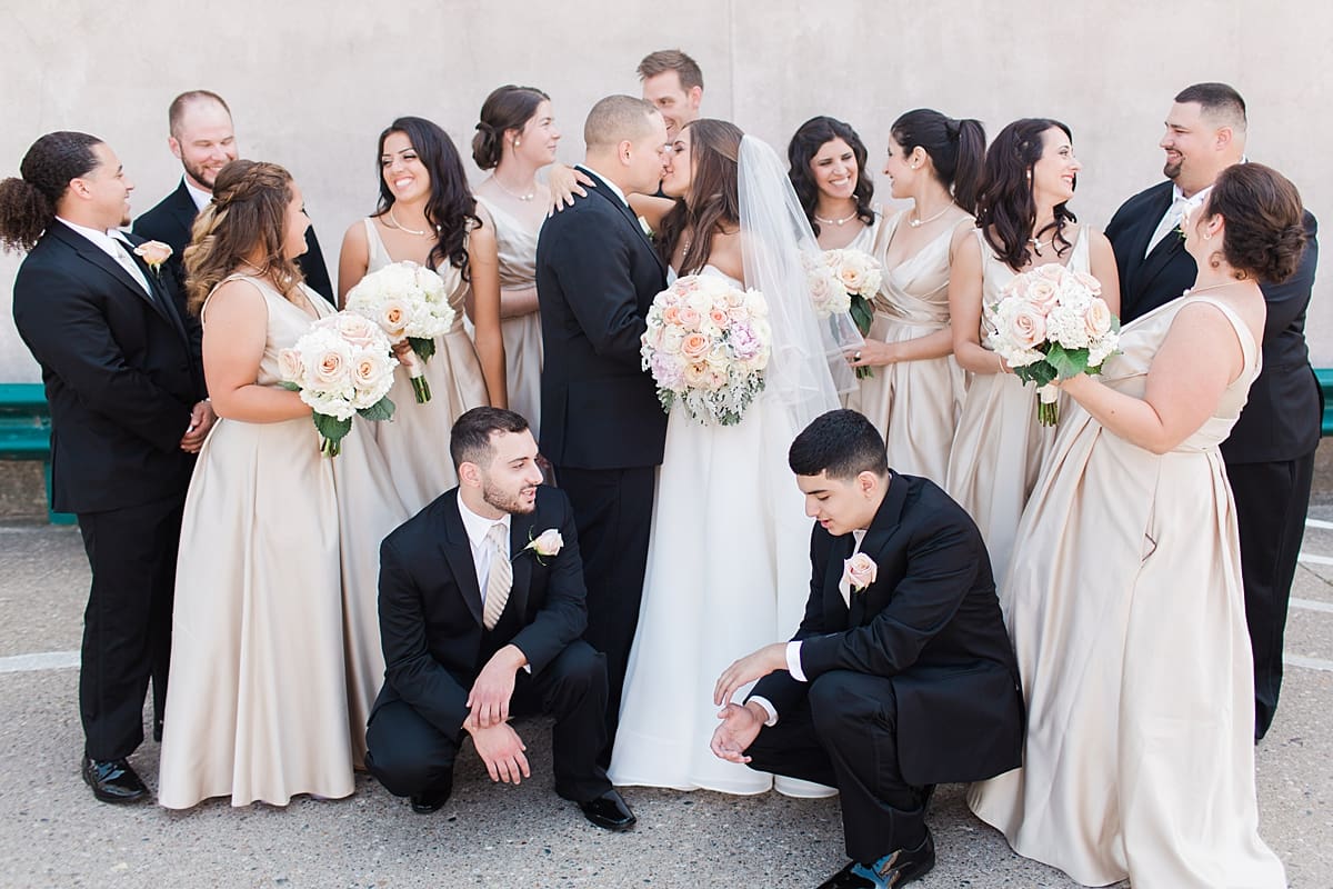 Arielle Peters Photography | Bride and groom kissing around friends on summer wedding day at The Inn at Harbor Springs in St. Joseph, Michigan.