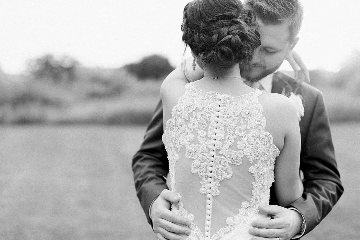 Arielle Peters Photography | Groom holding bride in open field on wedding day at the Banquets at The Croatian Center in Merrillville, Indiana.
