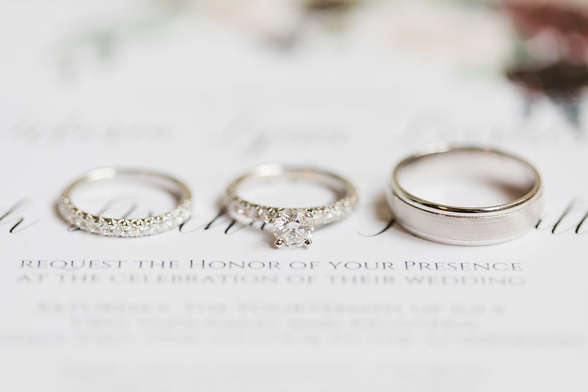 Arielle Peters Photography | Wedding rings lined up on wedding invitation on wedding day at Newlife Community Church in Chicago, Illinois.