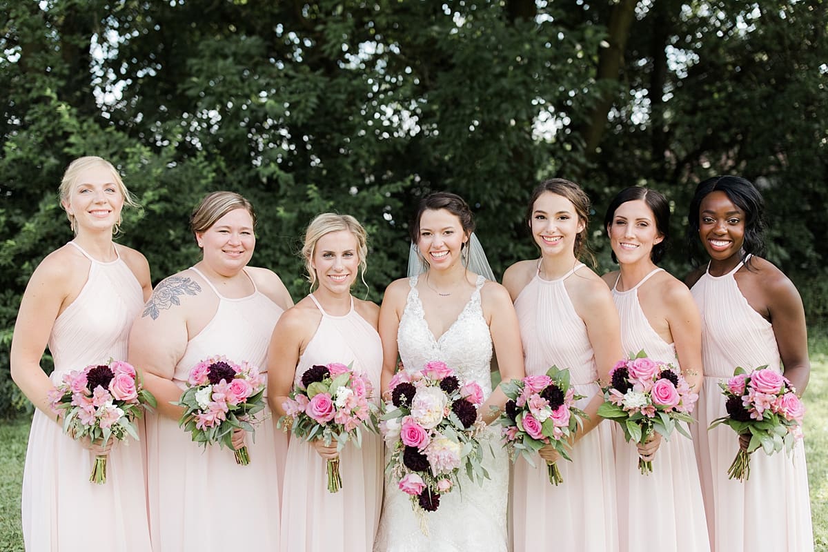 Arielle Peters Photography | Bride and bridesmaids holding bouquets outside on wedding day at Newlife Community Church in Chicago, Illinois.