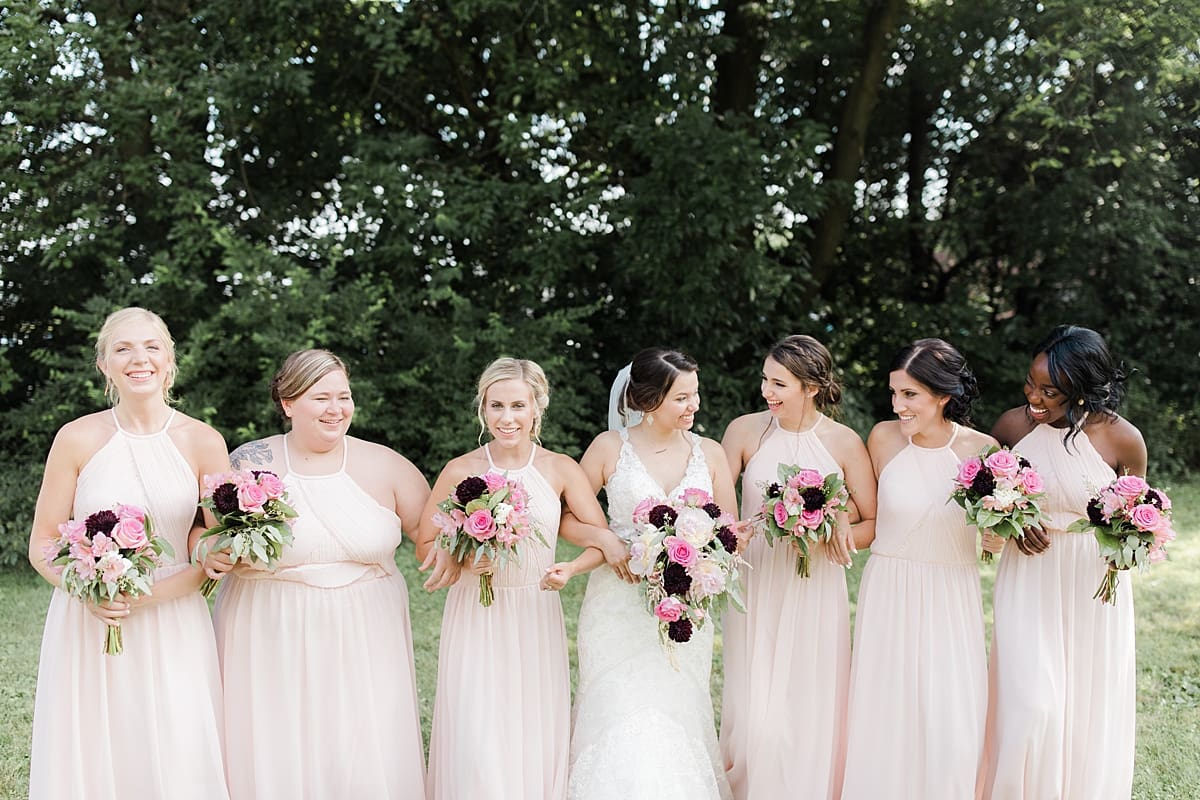 Arielle Peters Photography | Bride and bridesmaids holding bouquets outside on wedding day at Newlife Community Church in Chicago, Illinois.