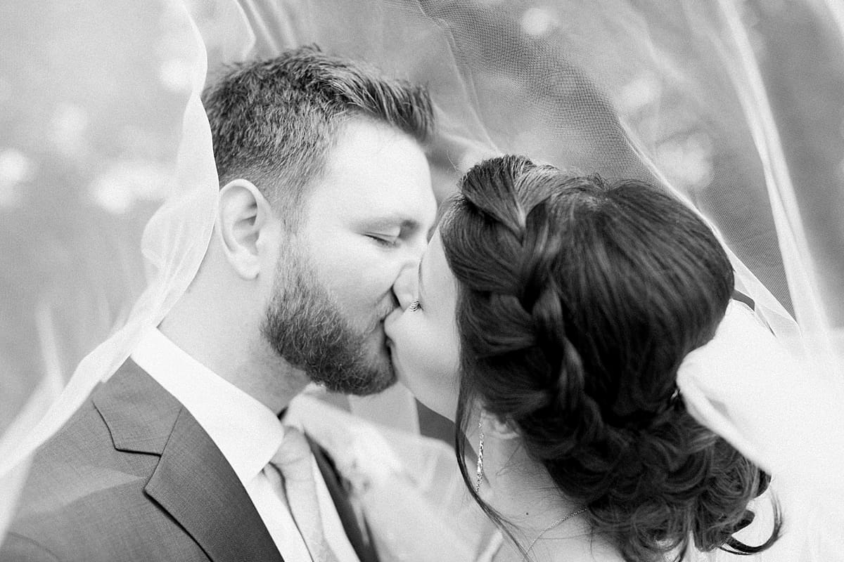 Arielle Peters Photography | Bride and groom kissing under veil on wedding day at Newlife Community Church in Chicago, Illinois.