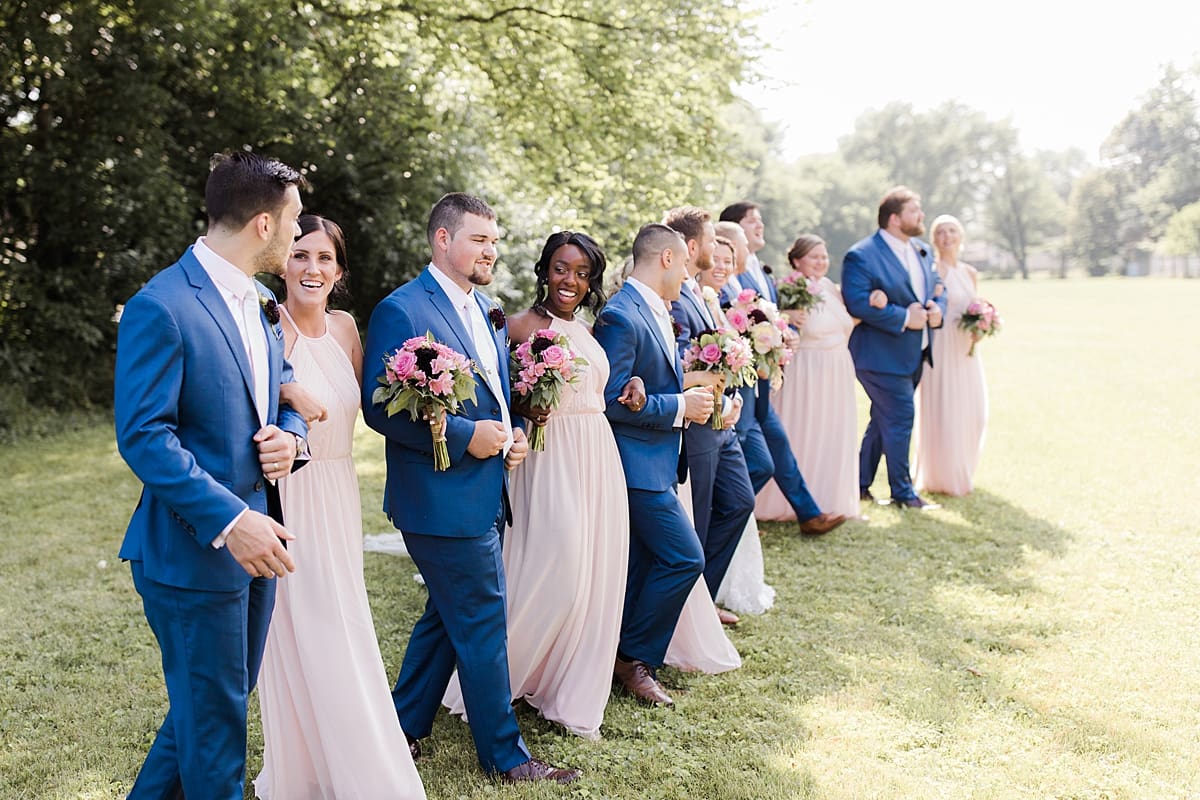 Arielle Peters Photography | Wedding party walking in open field on wedding day at Newlife Community Church in Chicago, Illinois.