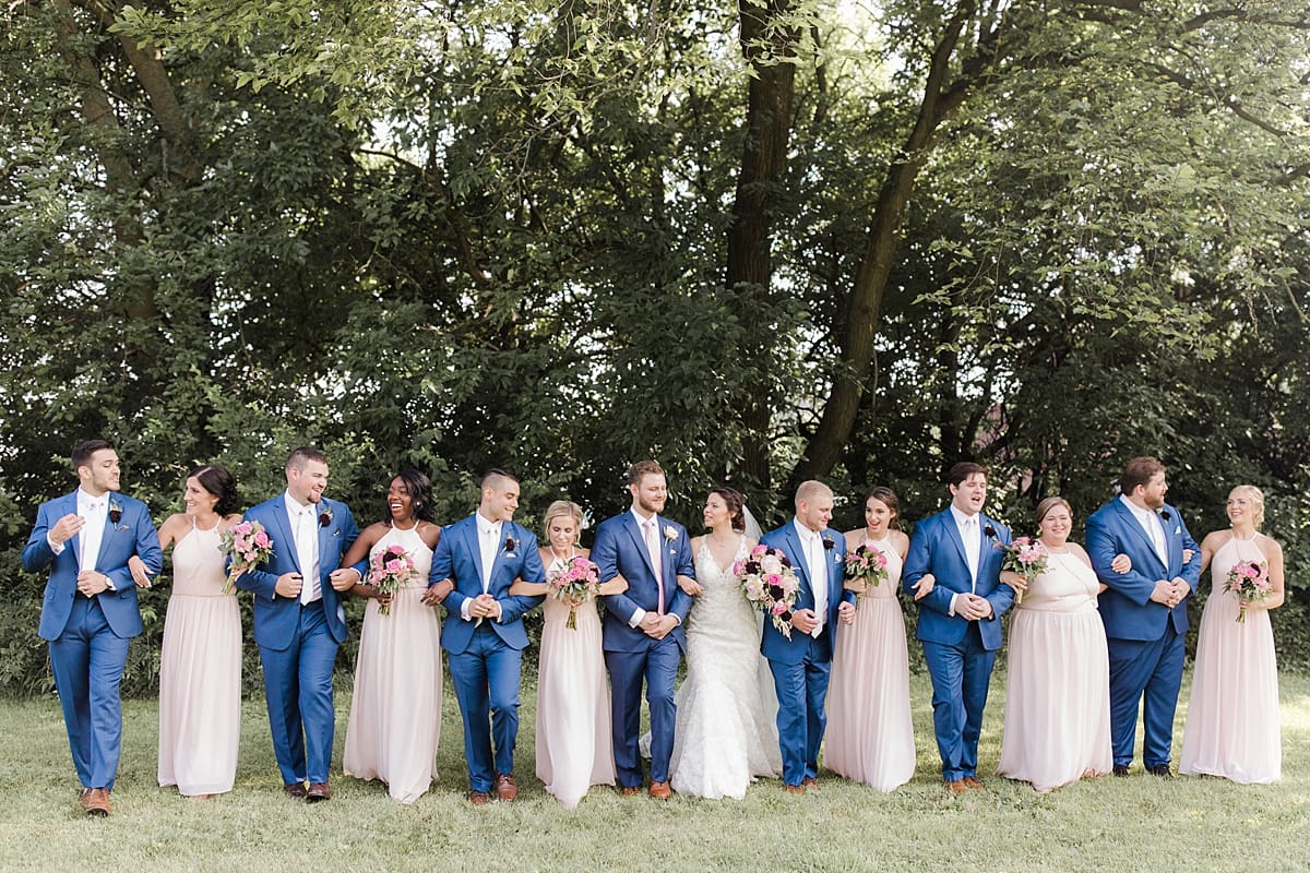 Arielle Peters Photography | Wedding party walking in open field on wedding day at Newlife Community Church in Chicago, Illinois.