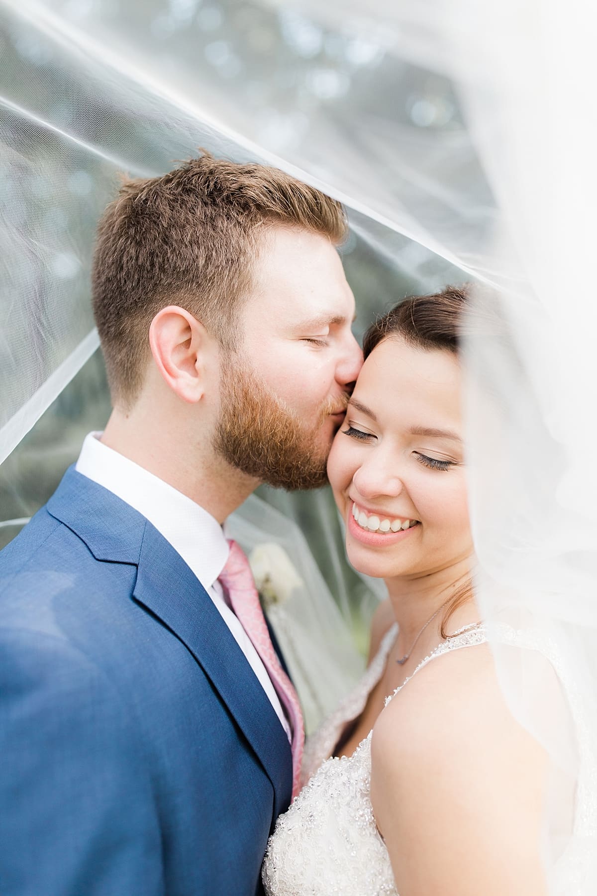 Arielle Peters Photography | Bride and groom kissing under veil on wedding day at Newlife Community Church in Chicago, Illinois.