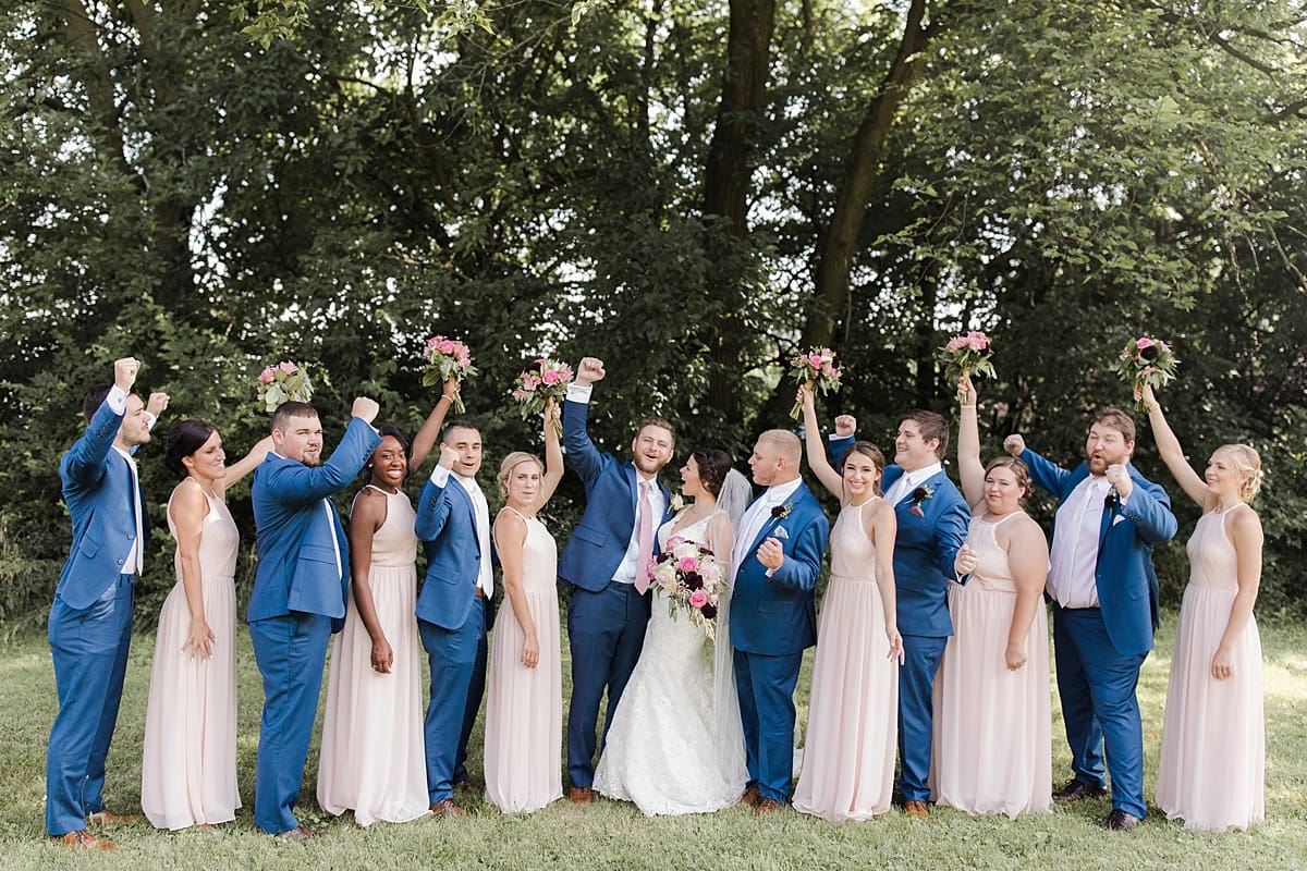 Arielle Peters Photography | Wedding party cheering in open field on wedding day at Newlife Community Church in Chicago, Illinois.