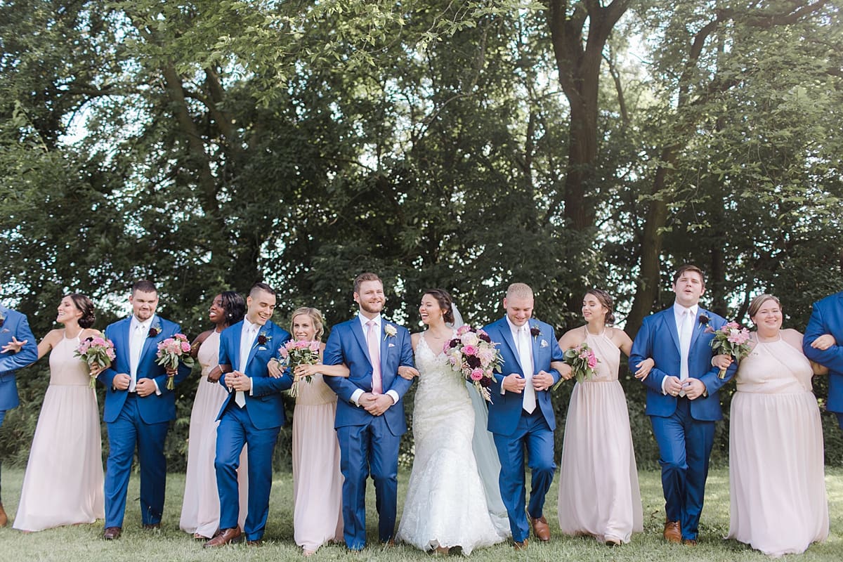Arielle Peters Photography | Wedding party walking in open field on wedding day at Newlife Community Church in Chicago, Illinois.