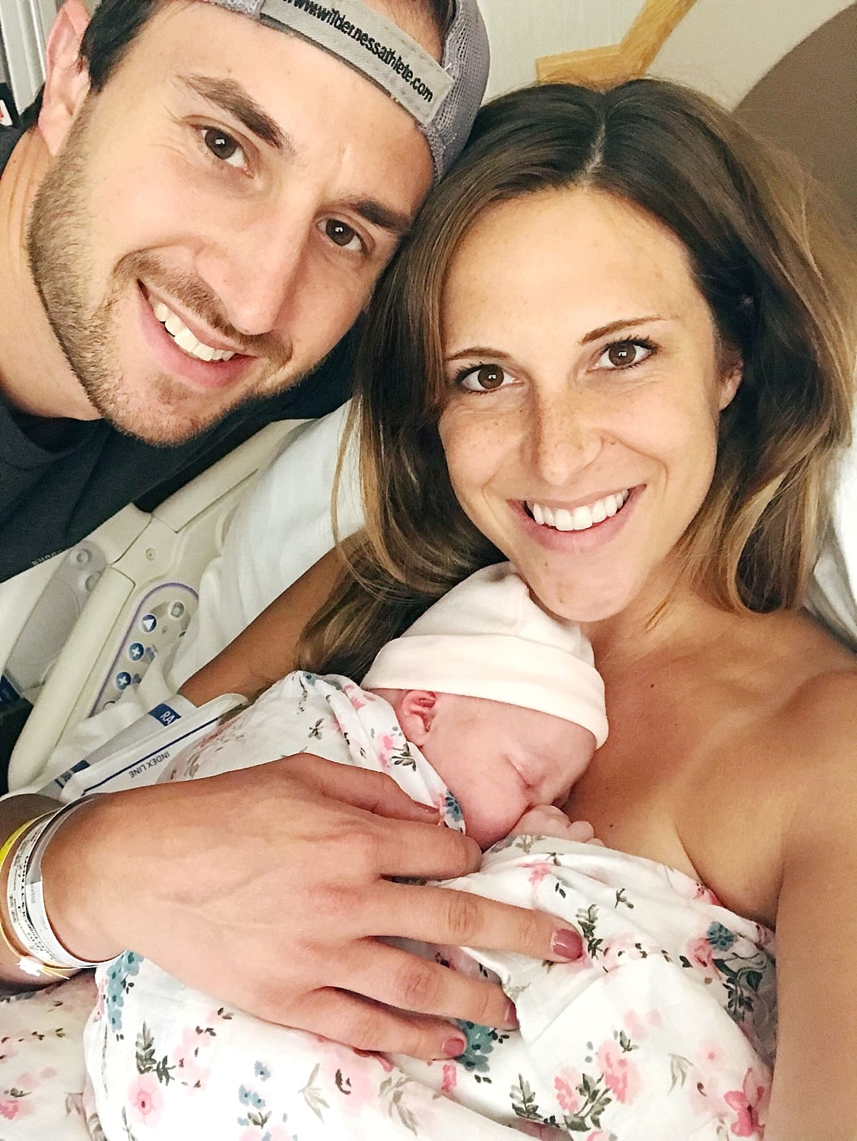 Arielle Peters Photography | Husband and wife smiling with their newborn baby.
