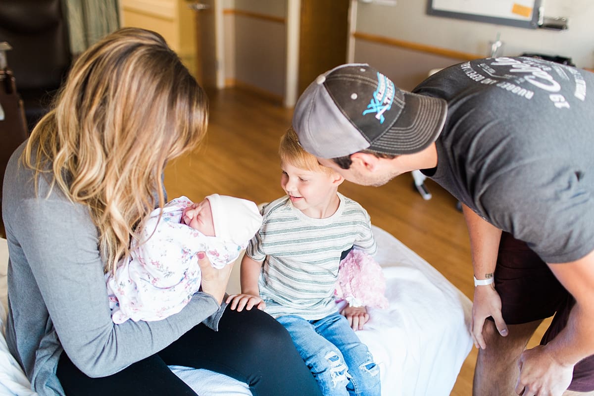 Arielle Peters Photography | Dad and son seeing newborn baby sister for the first time.