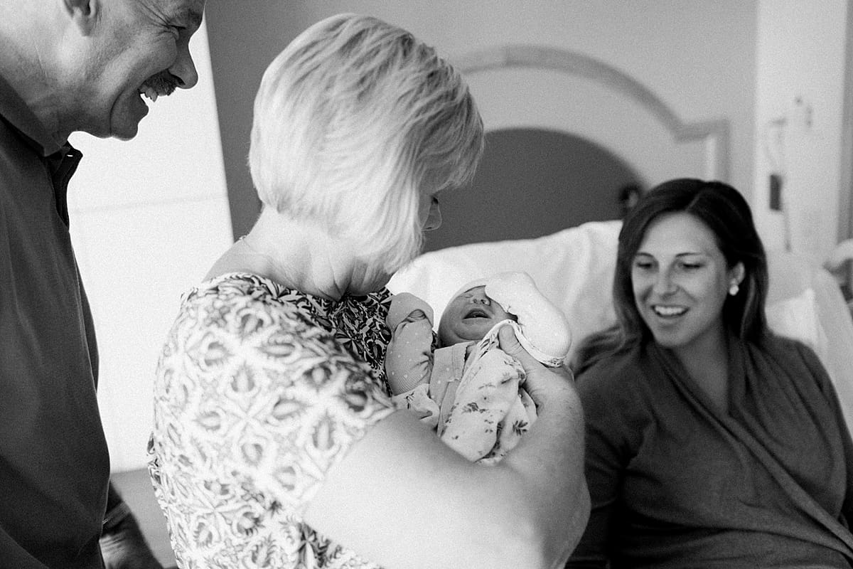 Arielle Peters Photography | Grandma and grandpa holding their newborn granddaughter.