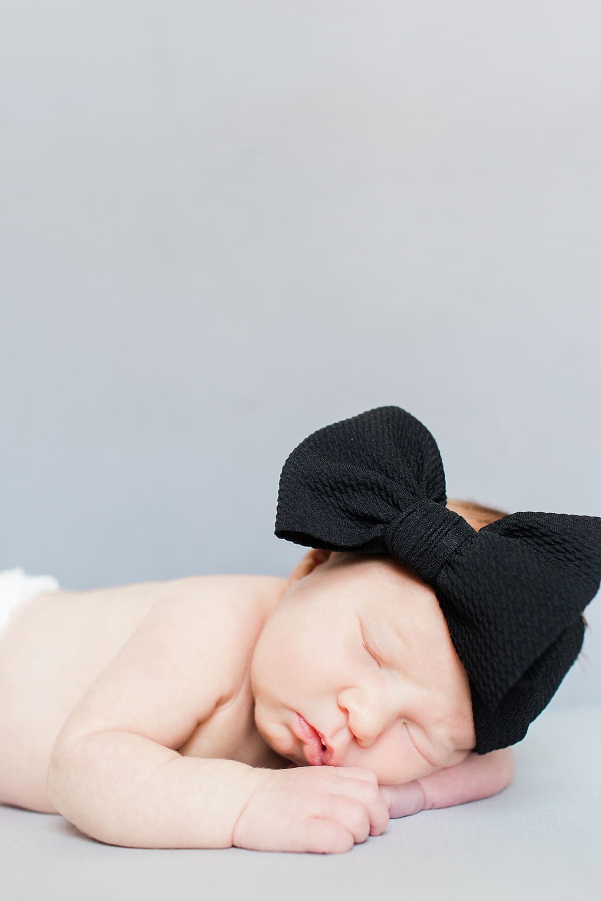Arielle Peters Photography | Newborn baby girl wearing a bow in one month photos.