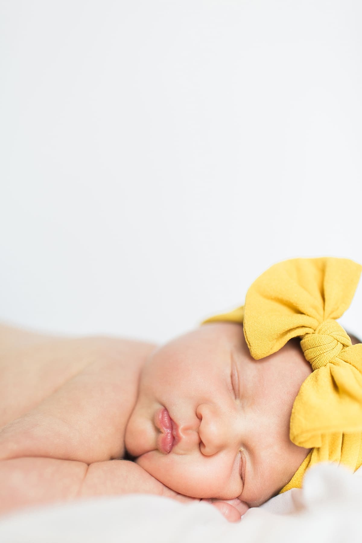 Arielle Peters Photography | Newborn baby girl wearing a bow in one month photos.