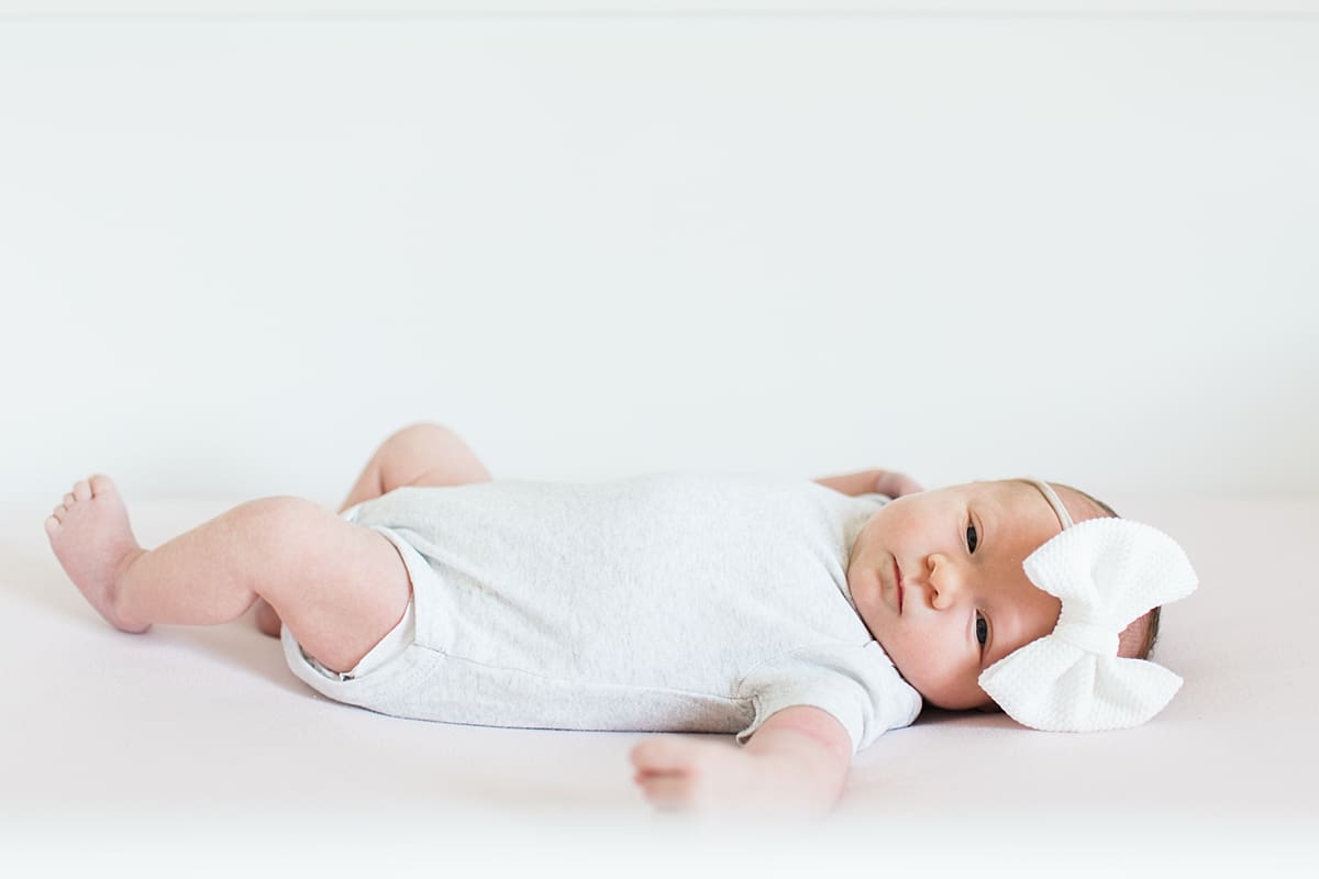 Arielle Peters Photography | Newborn baby girl wearing bow in one month photos.