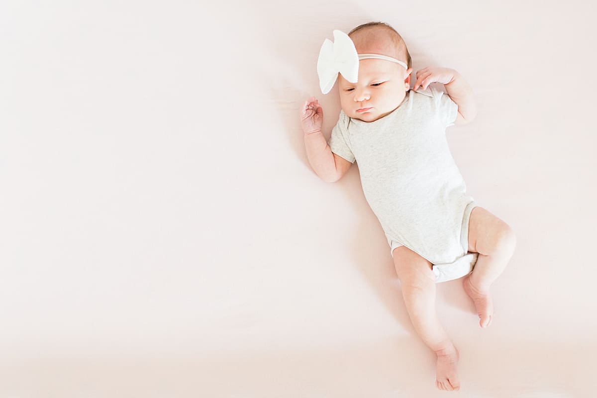 Arielle Peters Photography | Newborn baby girl wearing bow in one month photos.