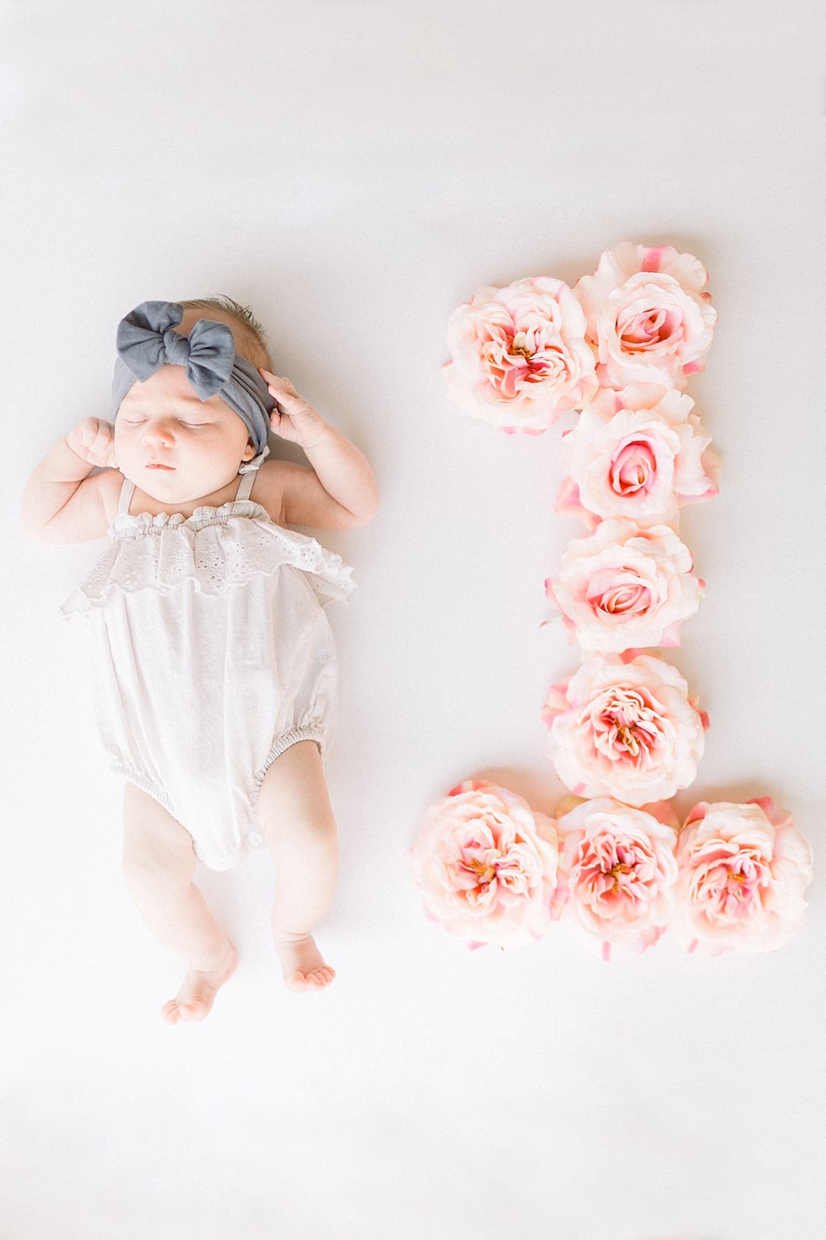 Arielle Peters Photography | Newborn baby girl sleeping next to floral one for one month photos. 