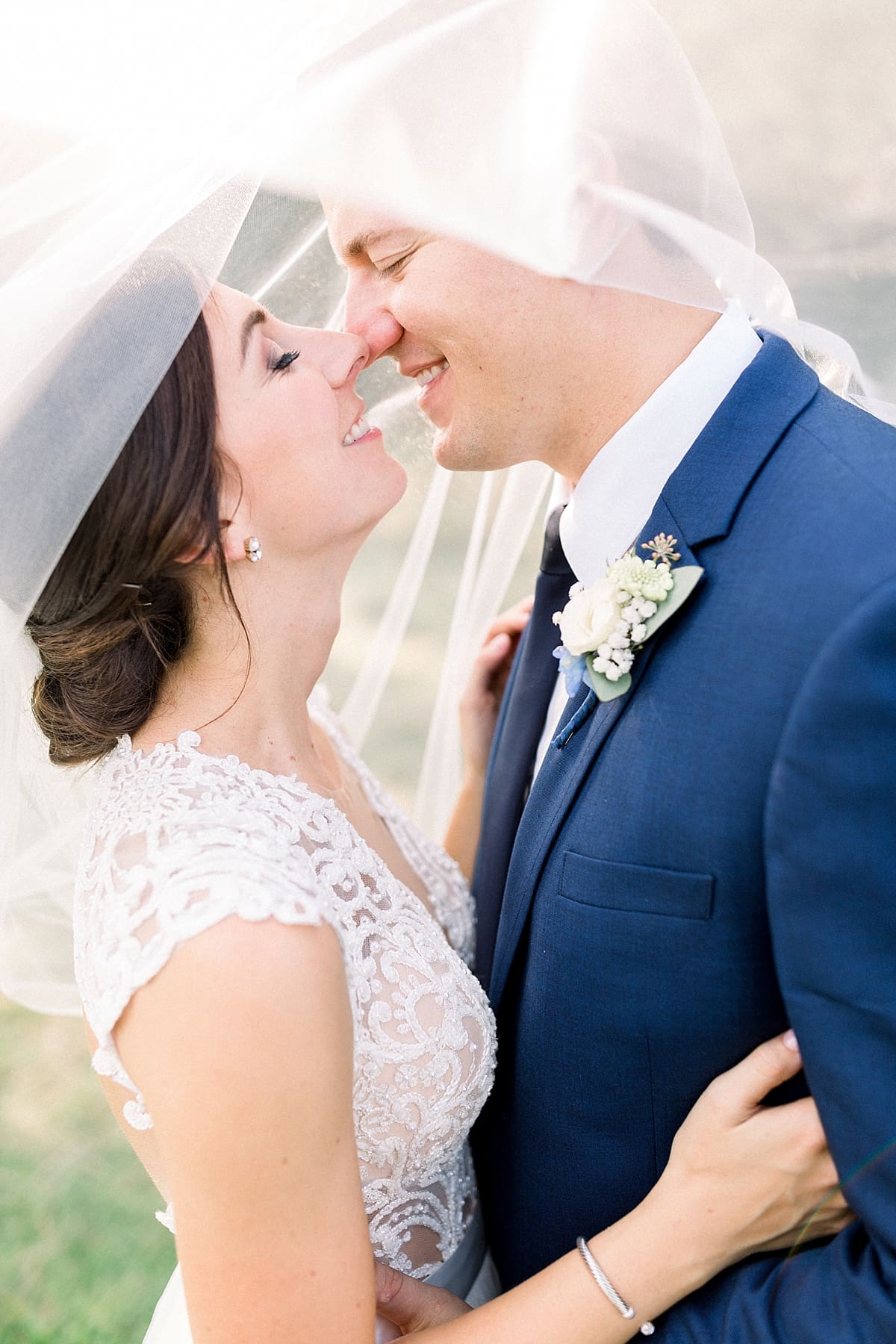 Arielle Peters Photography | Bride and groom kissing under veil at The Blue Heron at Blackthorn in South Bend, Indiana on wedding day.