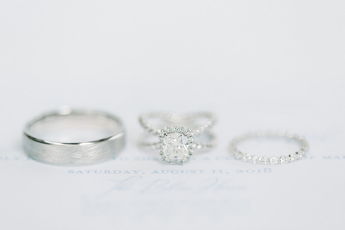 Arielle Peters Photography | Wedding rings lined up on wedding invitation at The Blue Heron at Blackthorn in South Bend, Indiana on wedding day.