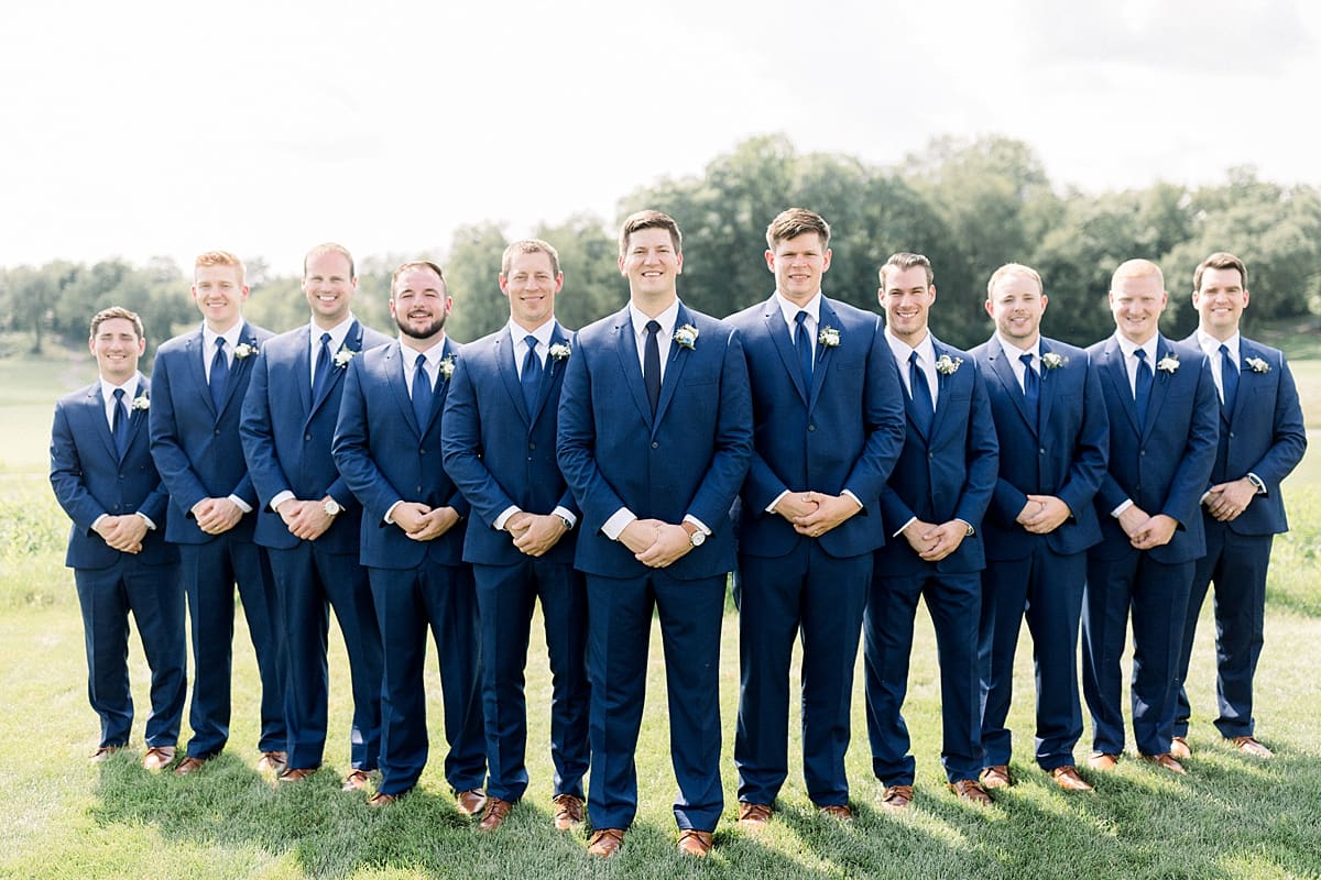 Arielle Peters Photography | Groom and groomsmen lined up smiling at The Blue Heron at Blackthorn in South Bend, Indiana on wedding day.