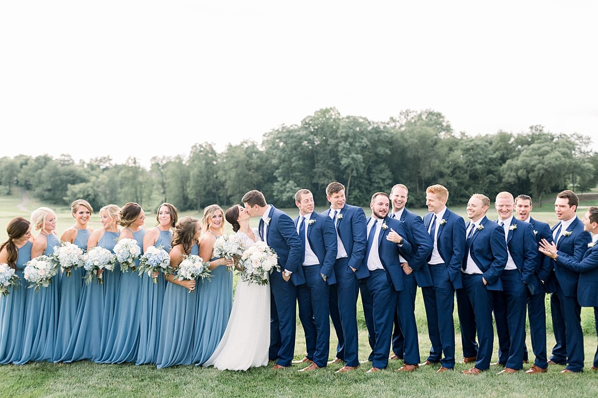 Arielle Peters Photography | Bride and groom kissing with wedding party at The Blue Heron at Blackthorn in South Bend, Indiana on wedding day.