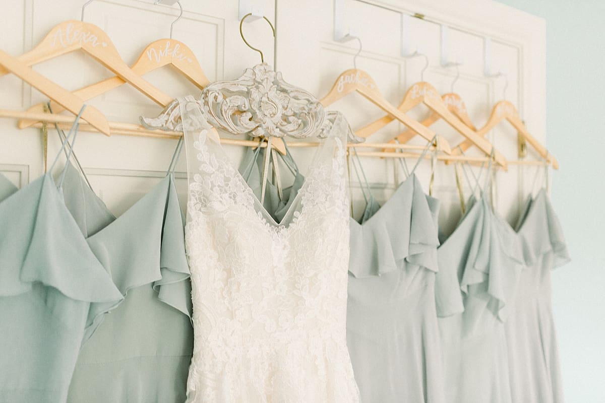 Arielle Peters Photography | Wedding gown hanging next to bridesmaids dresses at Sycamore Hills Golf Club in Fort Wayne, Indiana on wedding day.