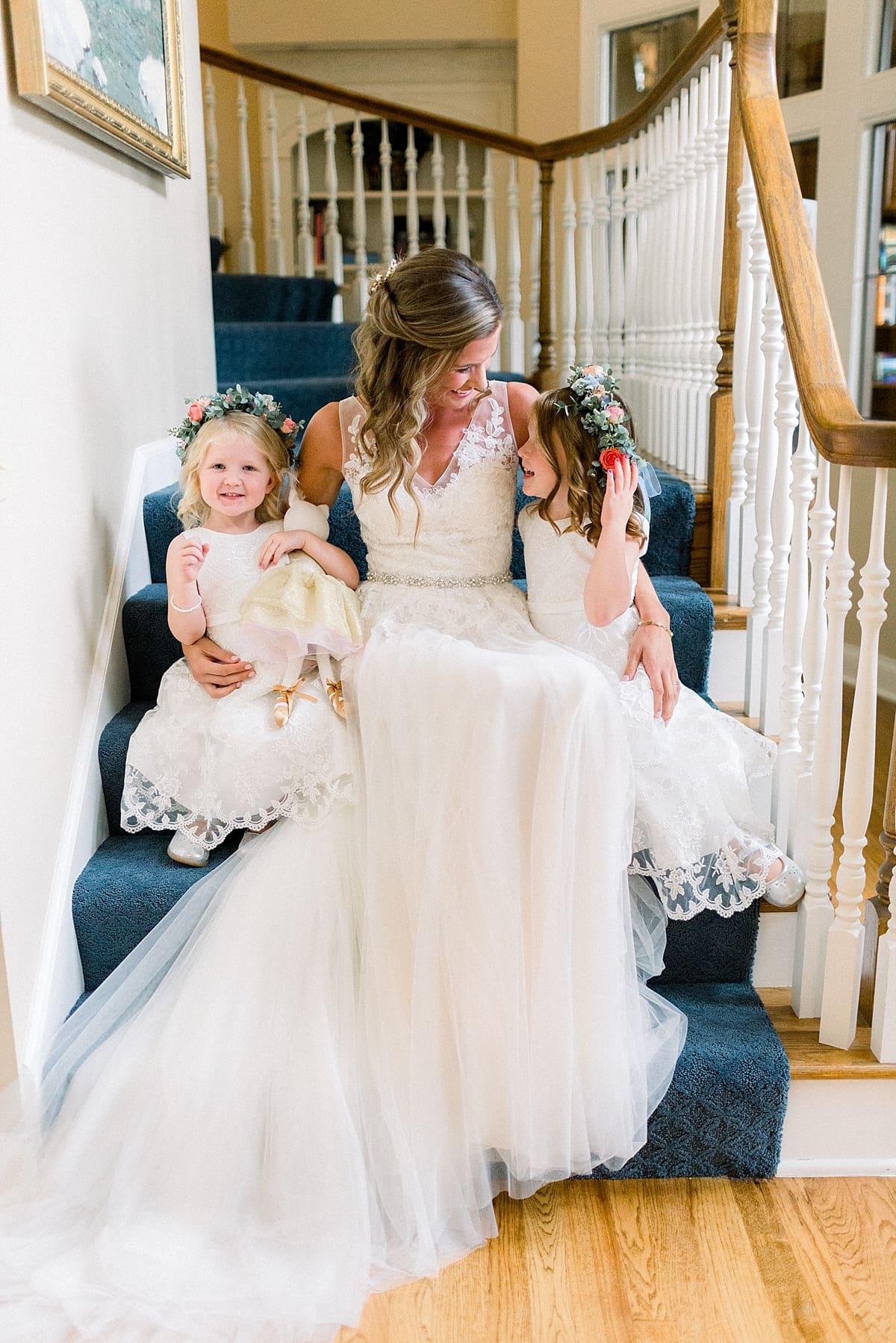 Arielle Peters Photography | Bride sitting with flower girls on stairs at Sycamore Hills Golf Club in Fort Wayne, Indiana on wedding day.