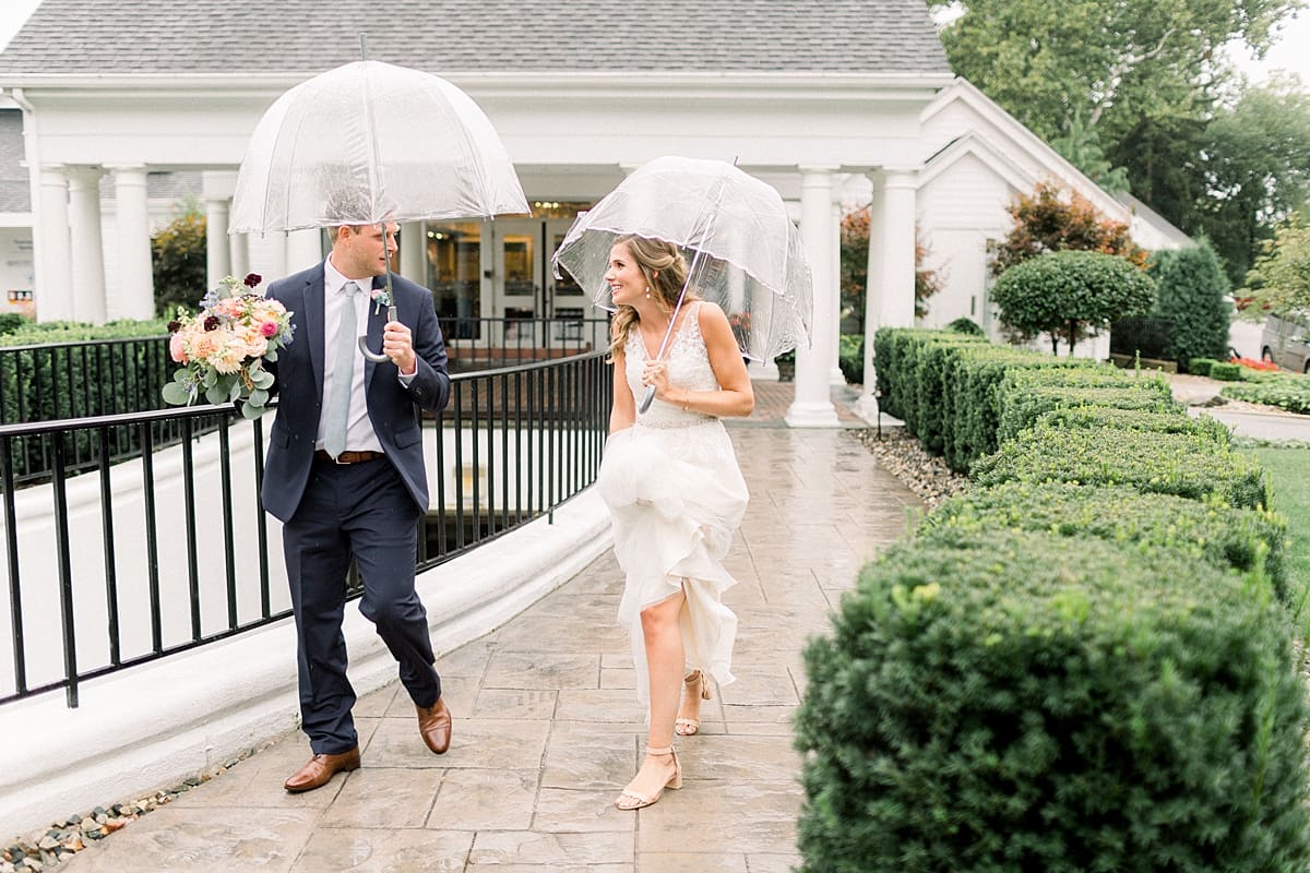 Arielle Peters Photography | Bride and groom walking outside in rain on wedding day at Sycamore Hills Golf Club in Fort Wayne, Indiana.