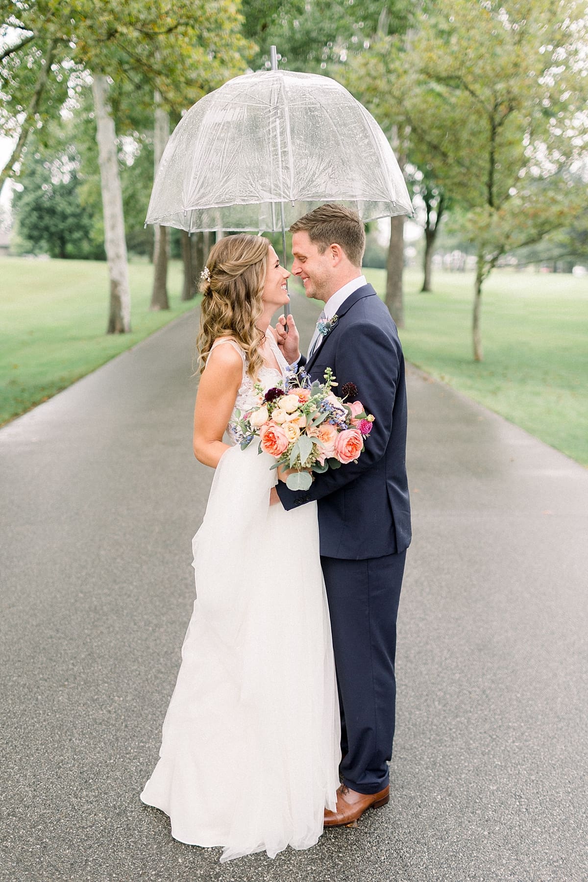 Arielle Peters Photography | Bride and groom kissing outside in rain on wedding day at Sycamore Hills Golf Club in Fort Wayne, Indiana.