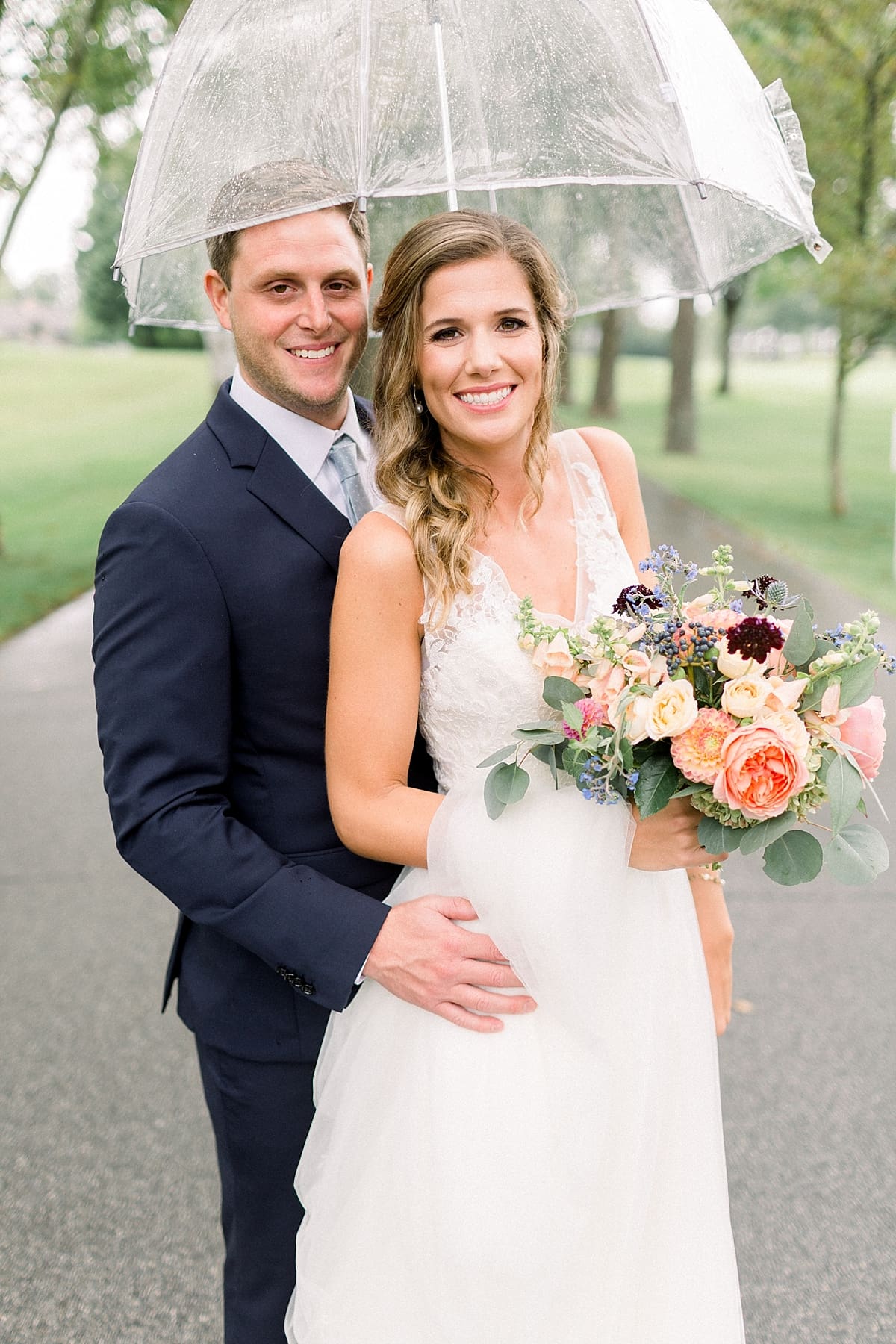 Arielle Peters Photography | Bride and groom smiling in the rain outside on wedding day at Sycamore Hills Golf Club in Fort Wayne, Indiana.