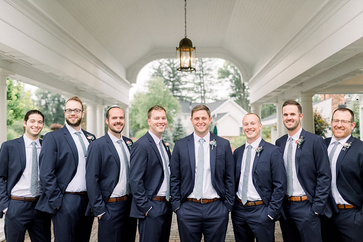 Arielle Peters Photography | Groom and groomsmen smiling with hands in pockets outside on wedding day at Sycamore Hills Golf Club in Fort Wayne, Indiana.