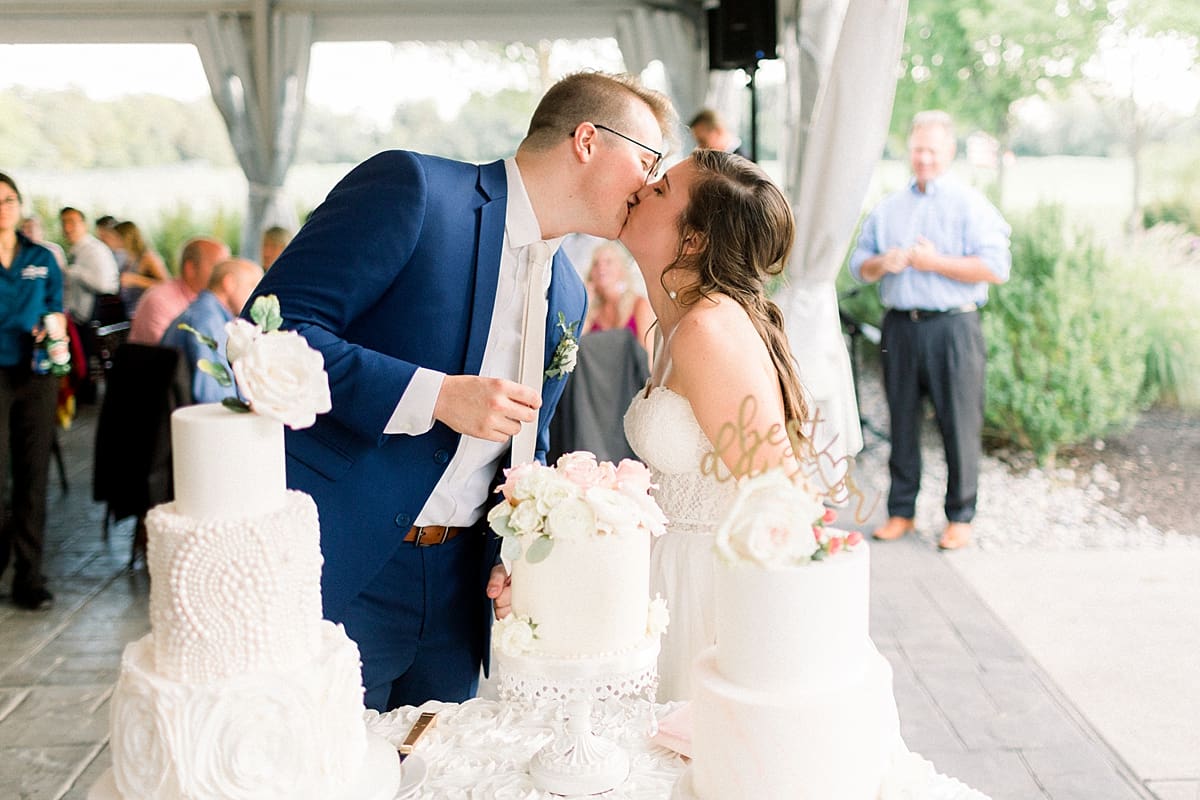 Arielle Peters Photography | Bride and groom kissing by the cake at the wedding reception at The Bridgewater Club in Carmel, Indiana on wedding day.