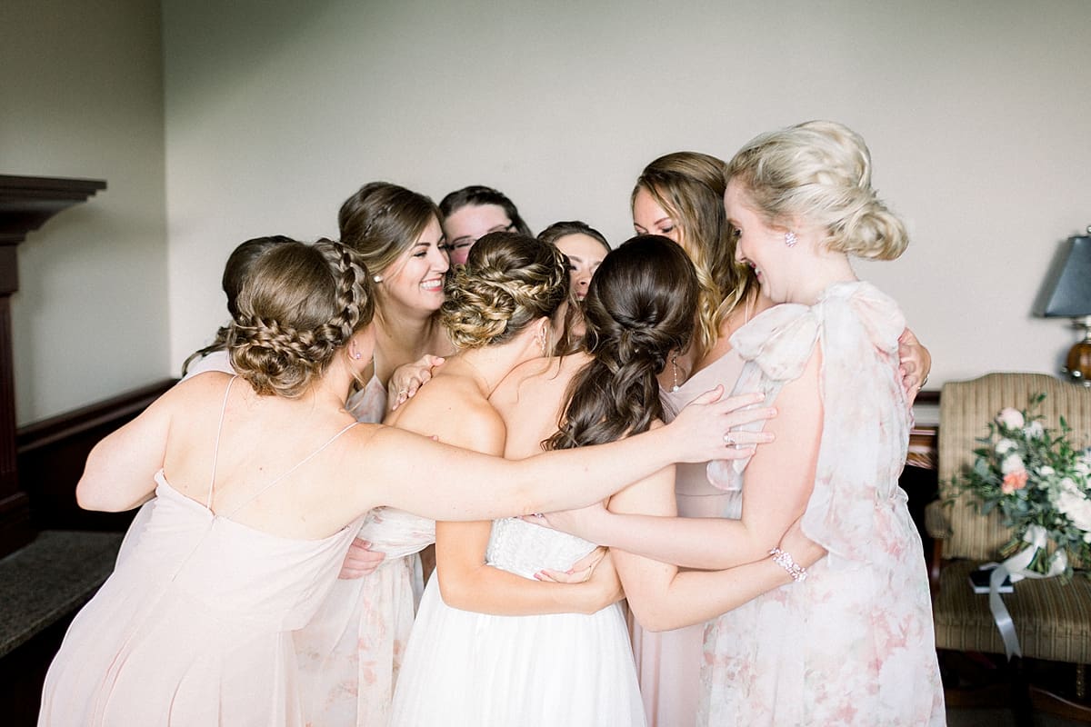 Arielle Peters Photography | Bride and bridesmaids hugging at The Bridgewater Club in Carmel, Indiana on wedding day.