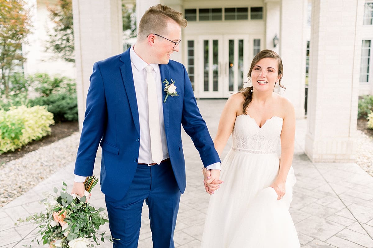 Arielle Peters Photography | Bride and groom holding hands and walking outside at The Bridgewater Club in Carmel, Indiana on wedding day.