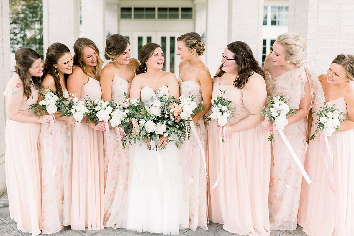 Arielle Peters Photography | Bride and bridesmaids smiling at each other outside at The Bridgewater Club in Carmel, Indiana on wedding day.