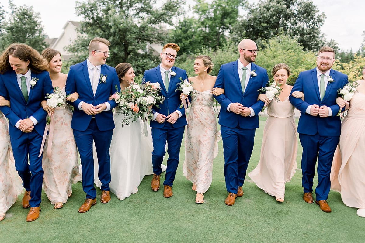Arielle Peters Photography | Wedding party linking arms outside at The Bridgewater Club in Carmel, Indiana on wedding day.
