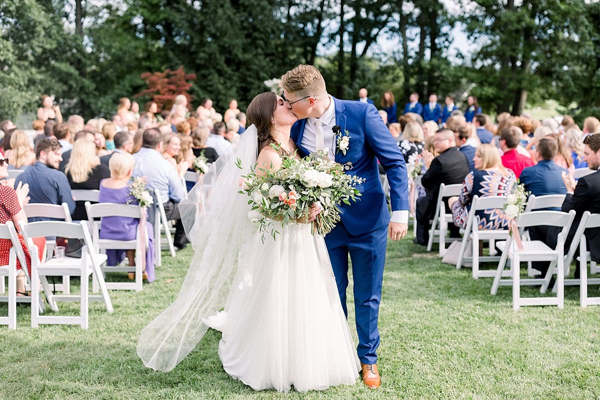 Arielle Peters Photography | Bride and groom kissing at the end of the aisle at The Bridgewater Club in Carmel, Indiana on wedding day.