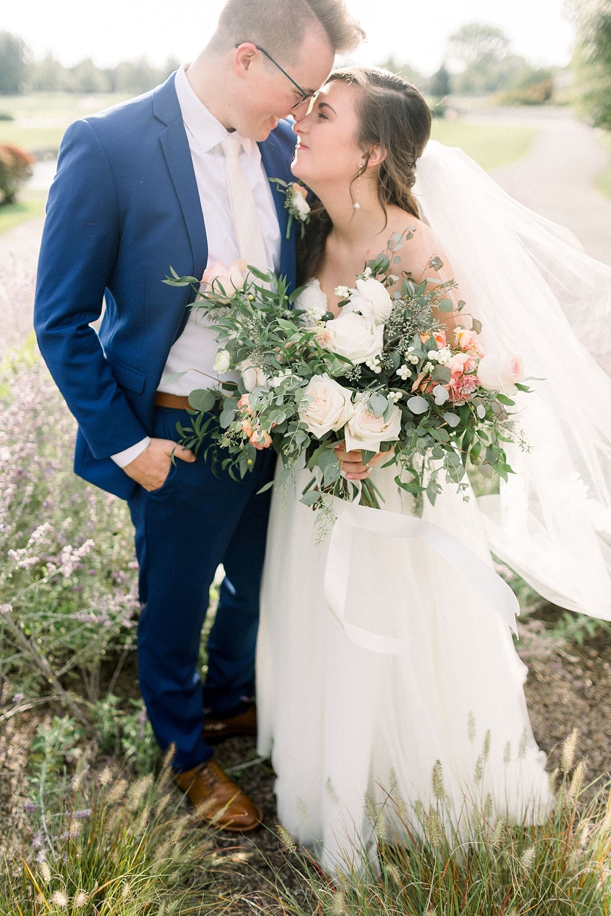 Arielle Peters Photography | Bride and groom smiling in a field at The Bridgewater Club in Carmel, Indiana on wedding day.