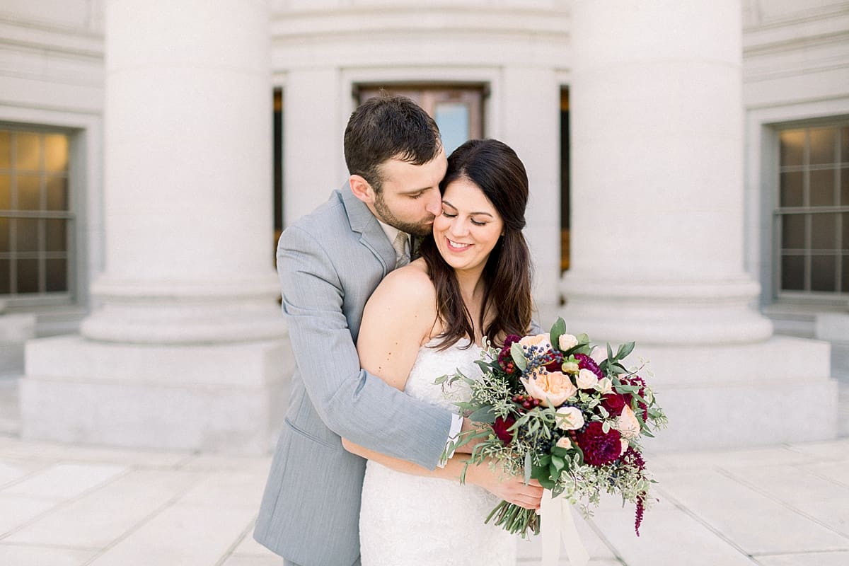 Arielle Peters Photography | Groom kissing the bride on wedding day outside in downtown Madison, Wisconsin.